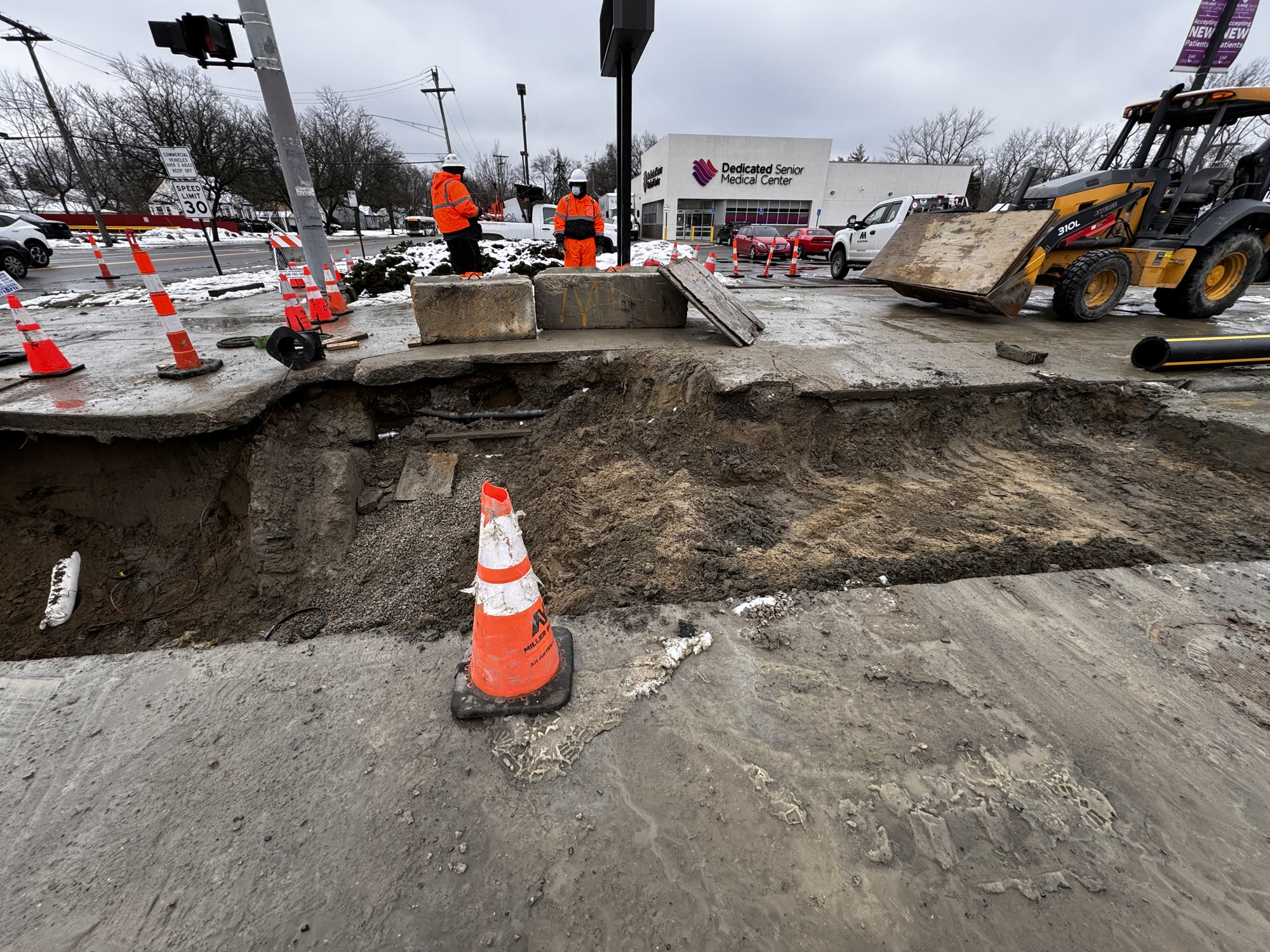 Excavation equipment and crew performing underground utility work