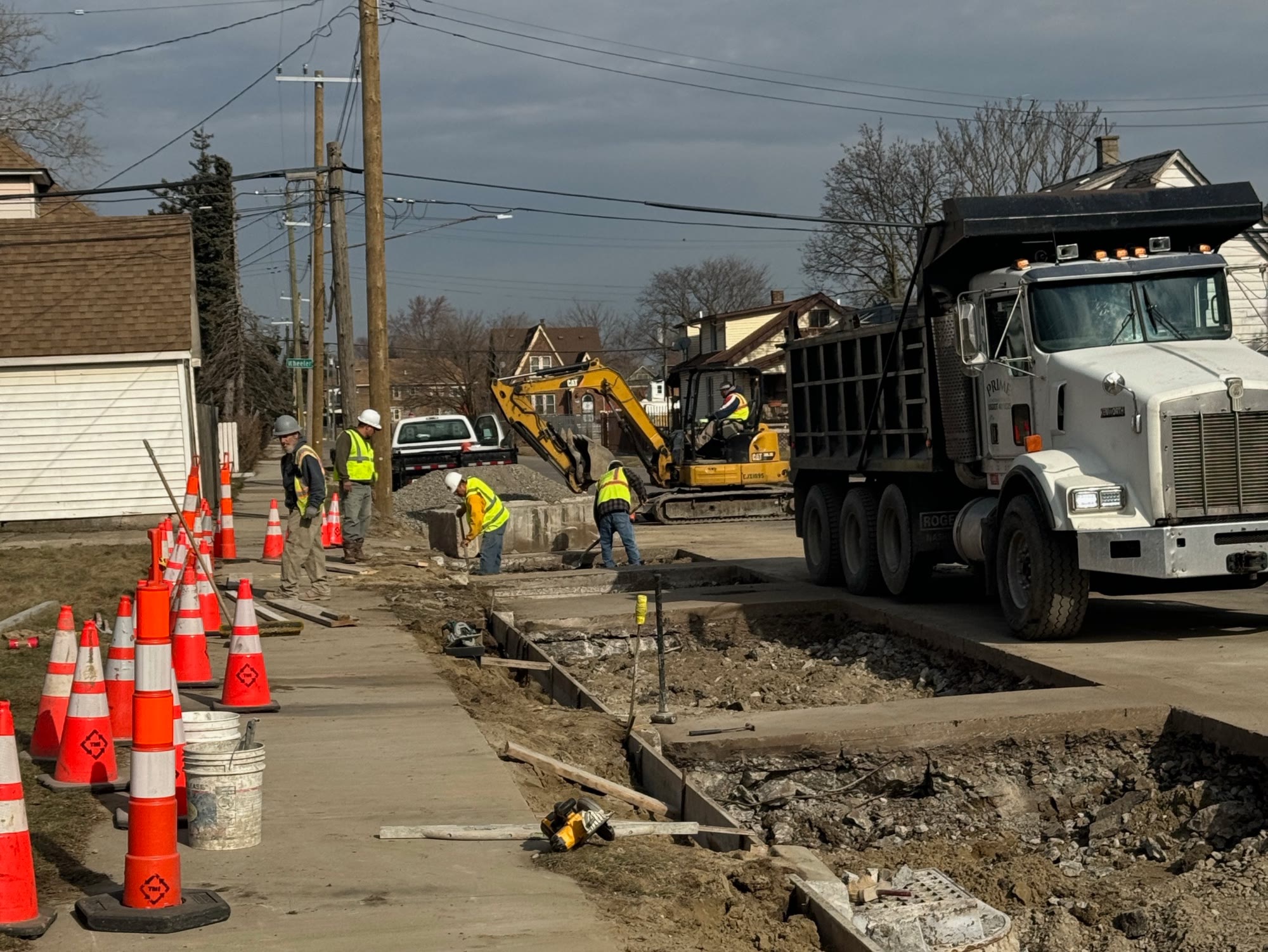 Prime Construction crew, excavator and dump truck working on a Detroit street