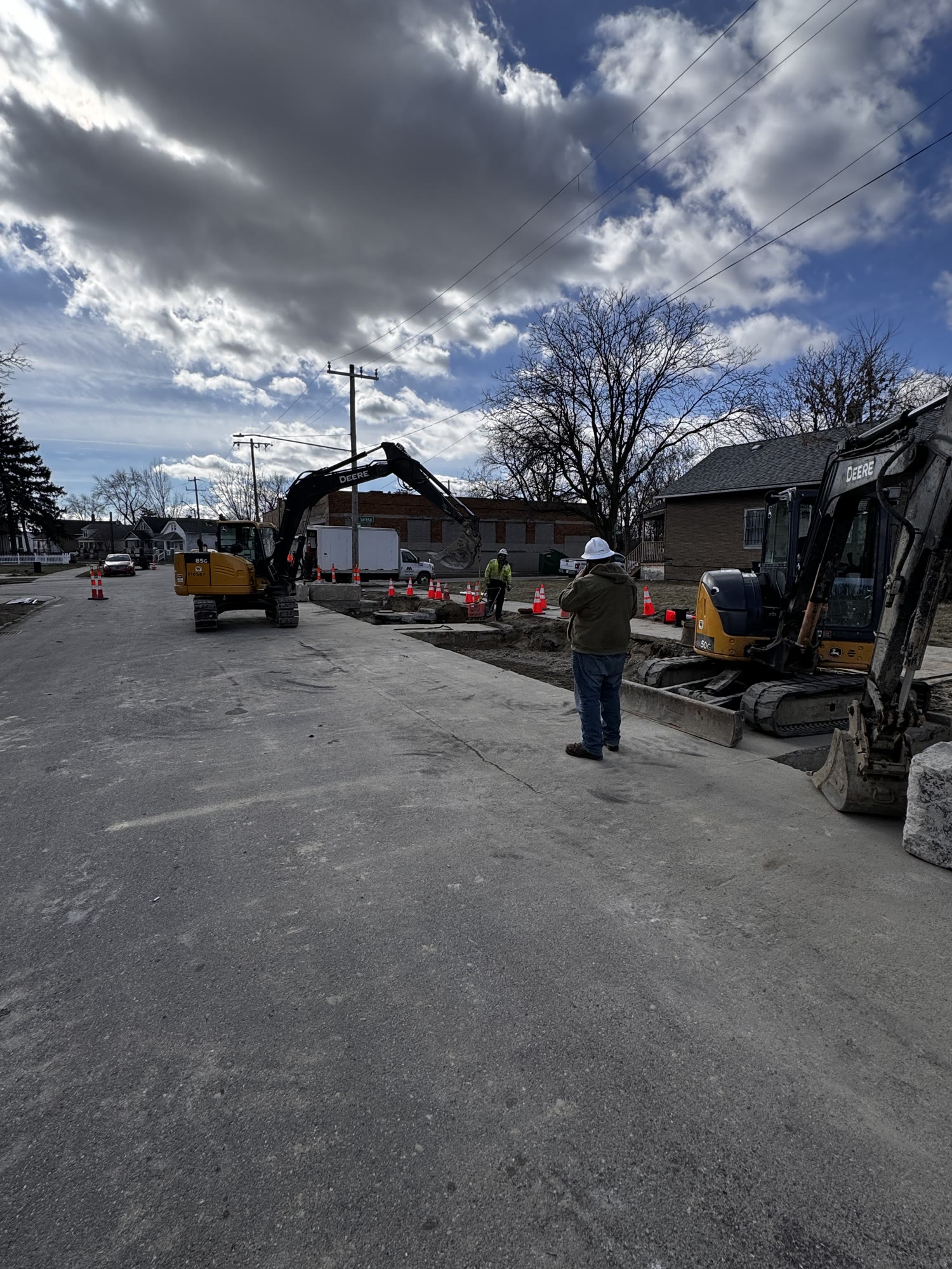 Two excavators working on a large roadway site in Metro Detroit